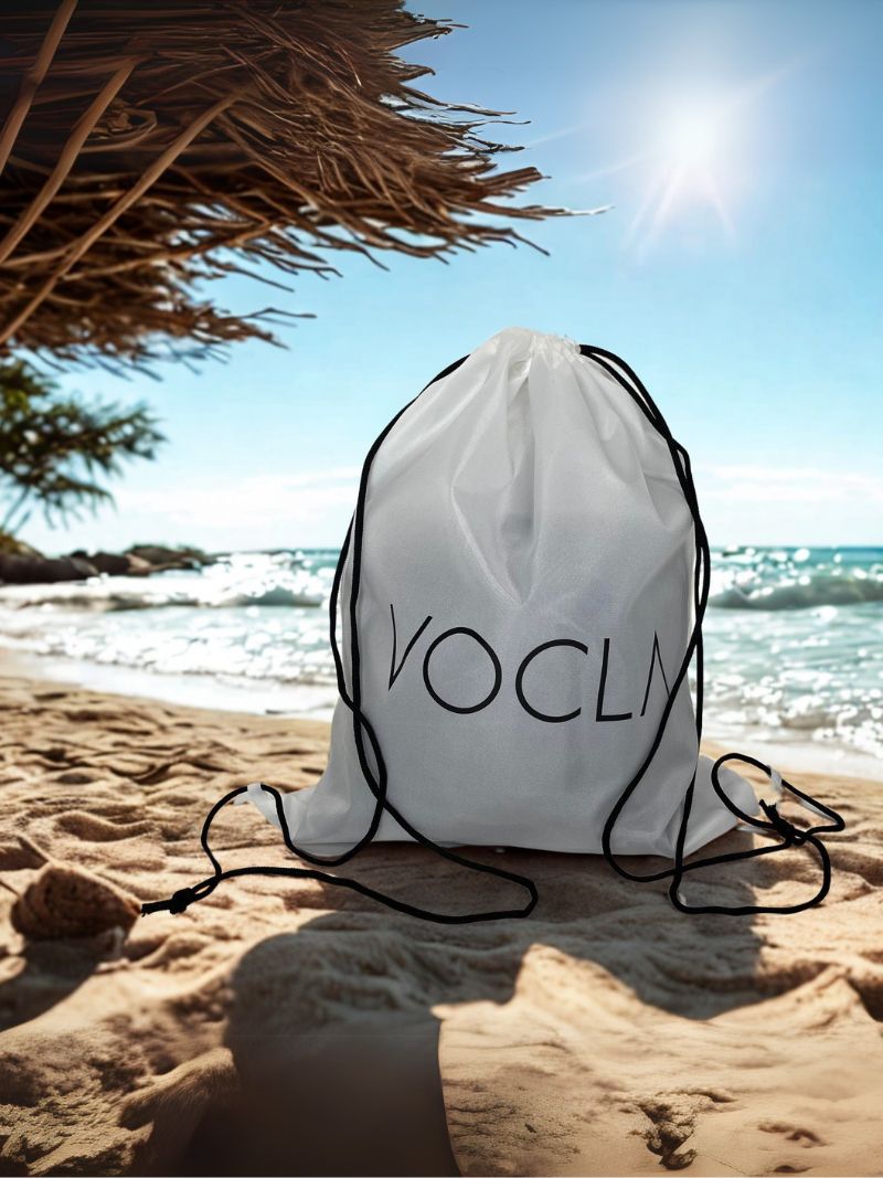 VOCLA drawstring bag in white, on a beach