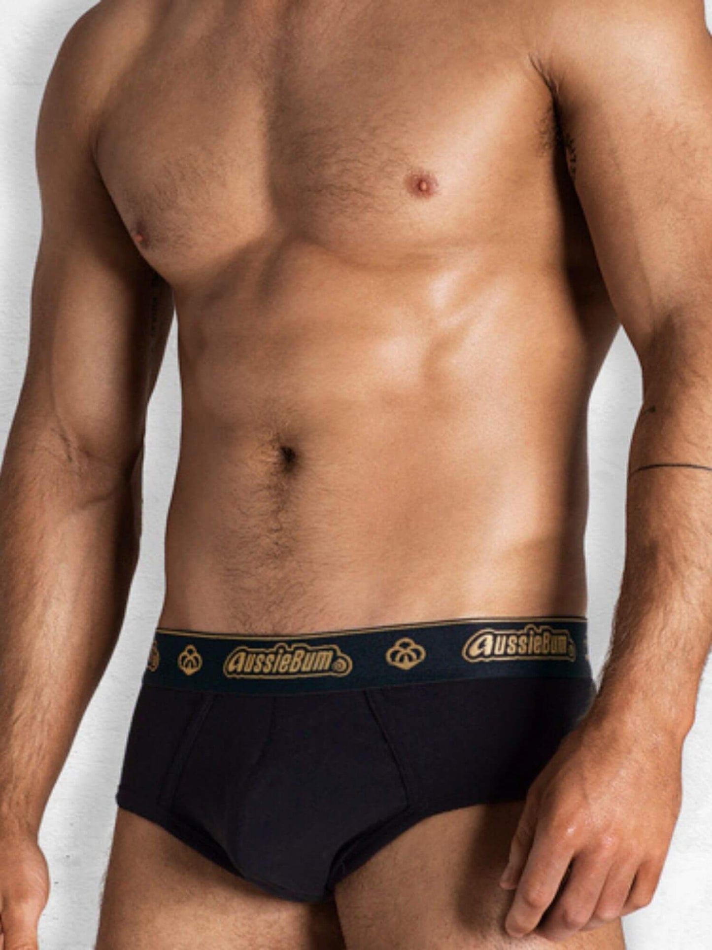 Man wearing black underwear with 'AussieBum' branding on a white background