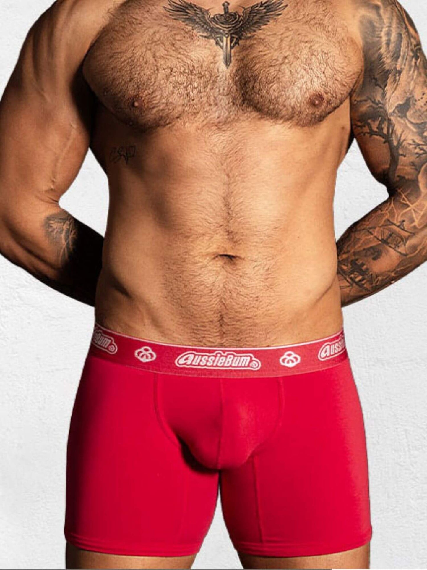 Man wearing red underwear with a visible brand logo on a plain background