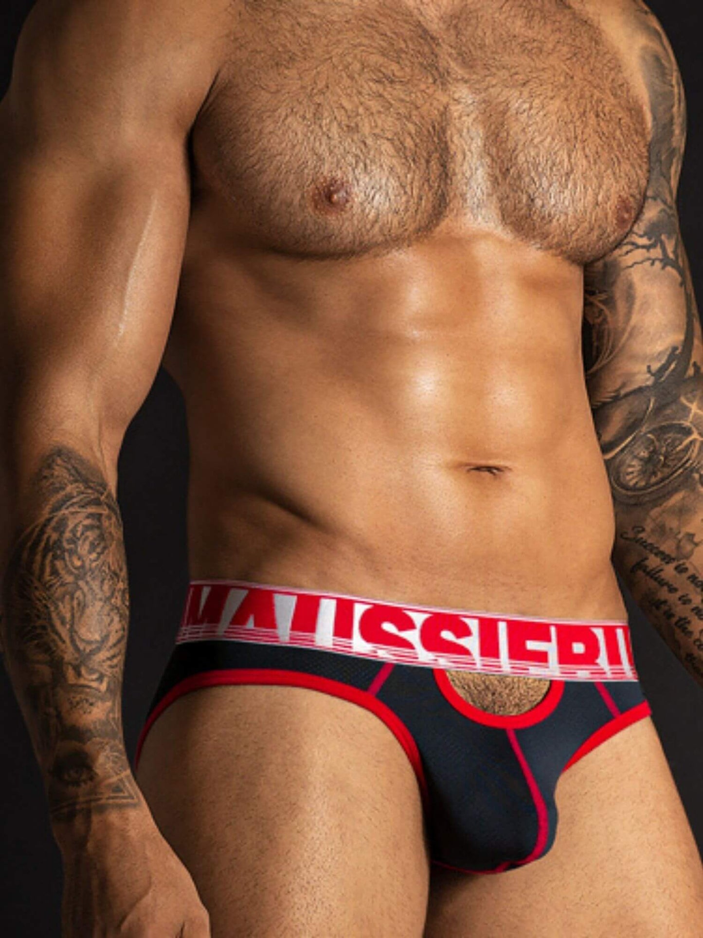 Man wearing a red and black underwear with visible brand logo against a black background