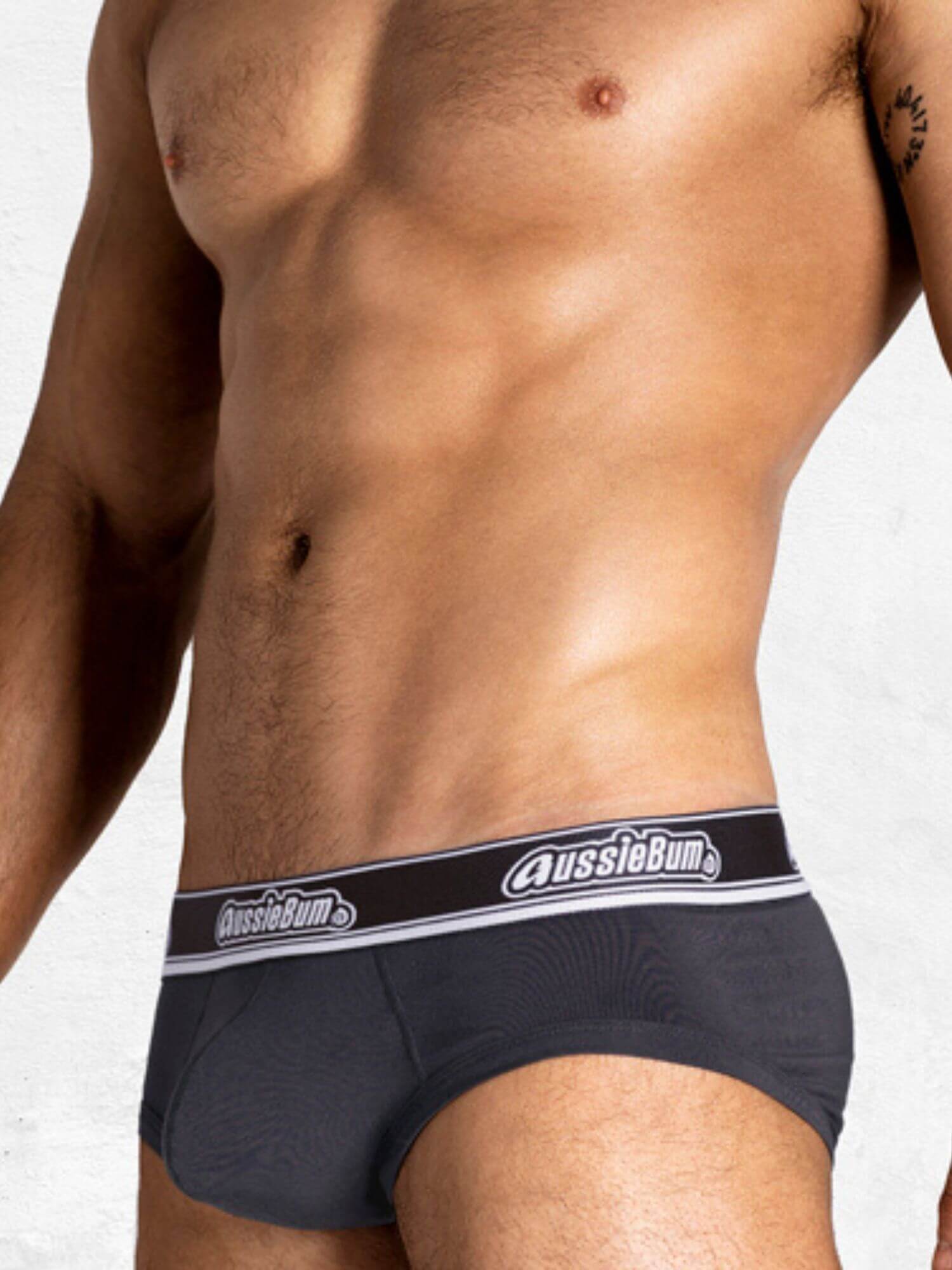 Man wearing navy blue underwear with 'AussieBum' brand logo on a white background