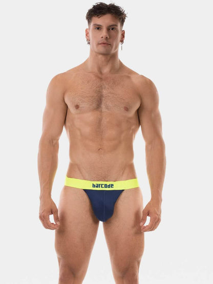 Man wearing blue and yellow swim briefs with 'Barcode' branding on a white background