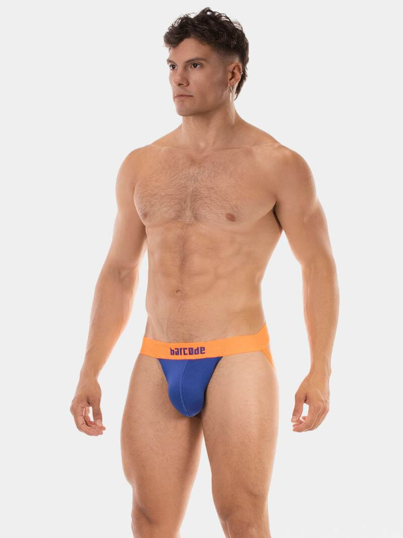 Man wearing orange and blue swim briefs on a white background