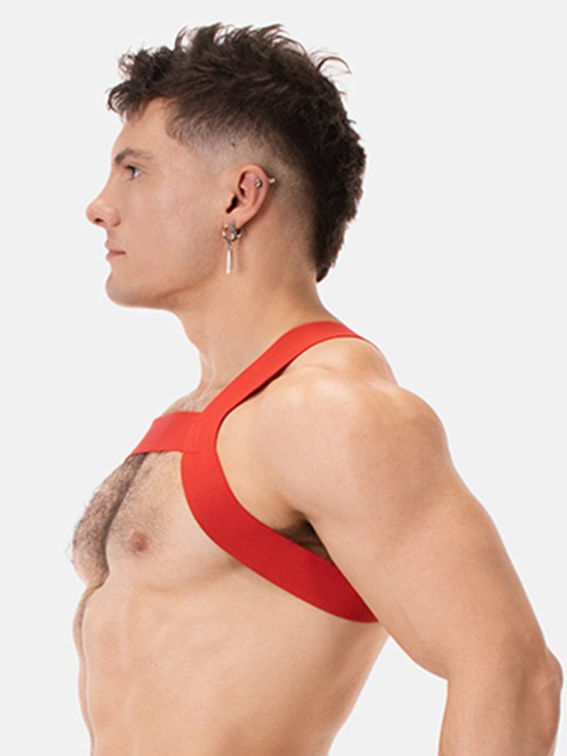 Man wearing a red chest harness against a white background