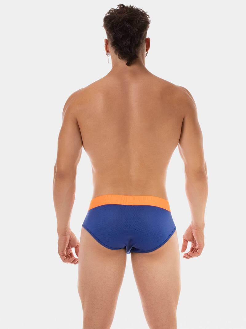 Man wearing blue and orange swim briefs on a white background