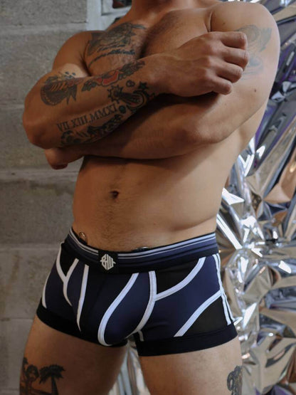 Person wearing black and white boxer briefs with a reflective background