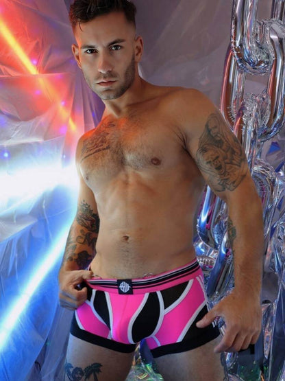 Man wearing pink and black underwear with a colorful, abstract background