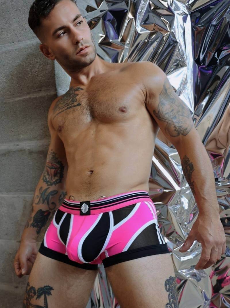 Man wearing pink and black patterned underwear with reflective silver background