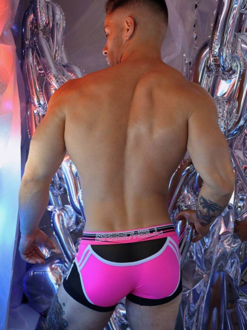 Man wearing bright pink underwear with a metallic background