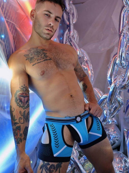 Man wearing blue and black patterned underwear with a colorful, abstract background