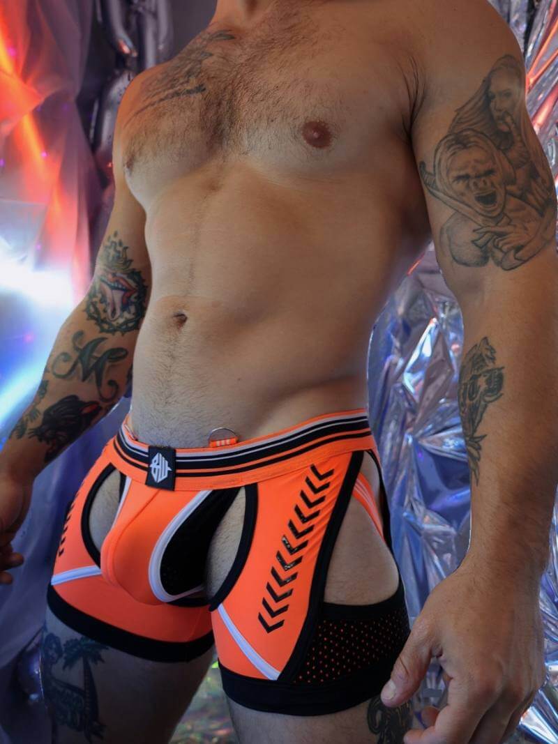 Person wearing orange and black underwear with a colorful background