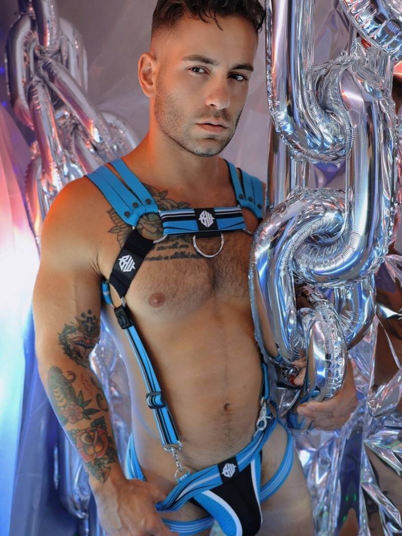 Man wearing a blue harness in front of decorative silver elements