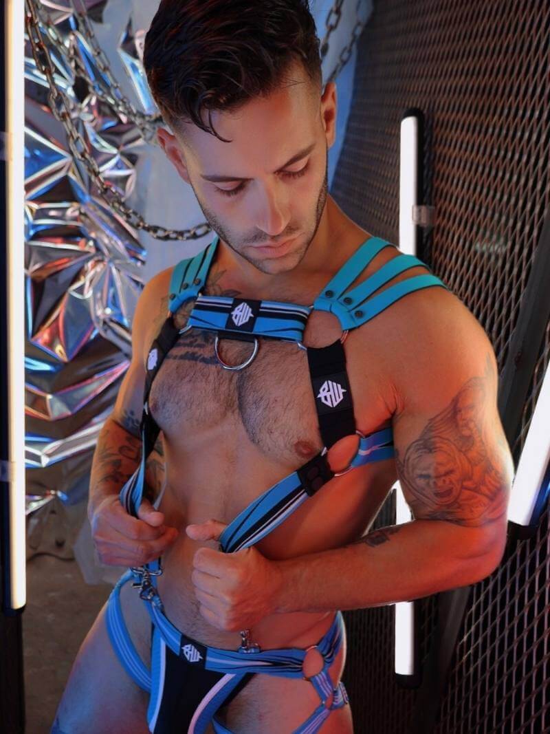 Man wearing a blue harness against a metallic background