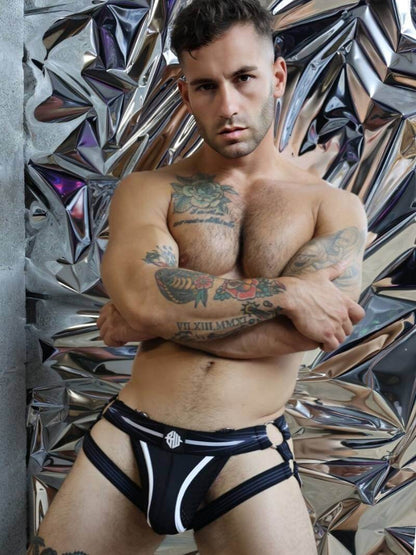 Man wearing black underwear with a reflective metallic wall background
