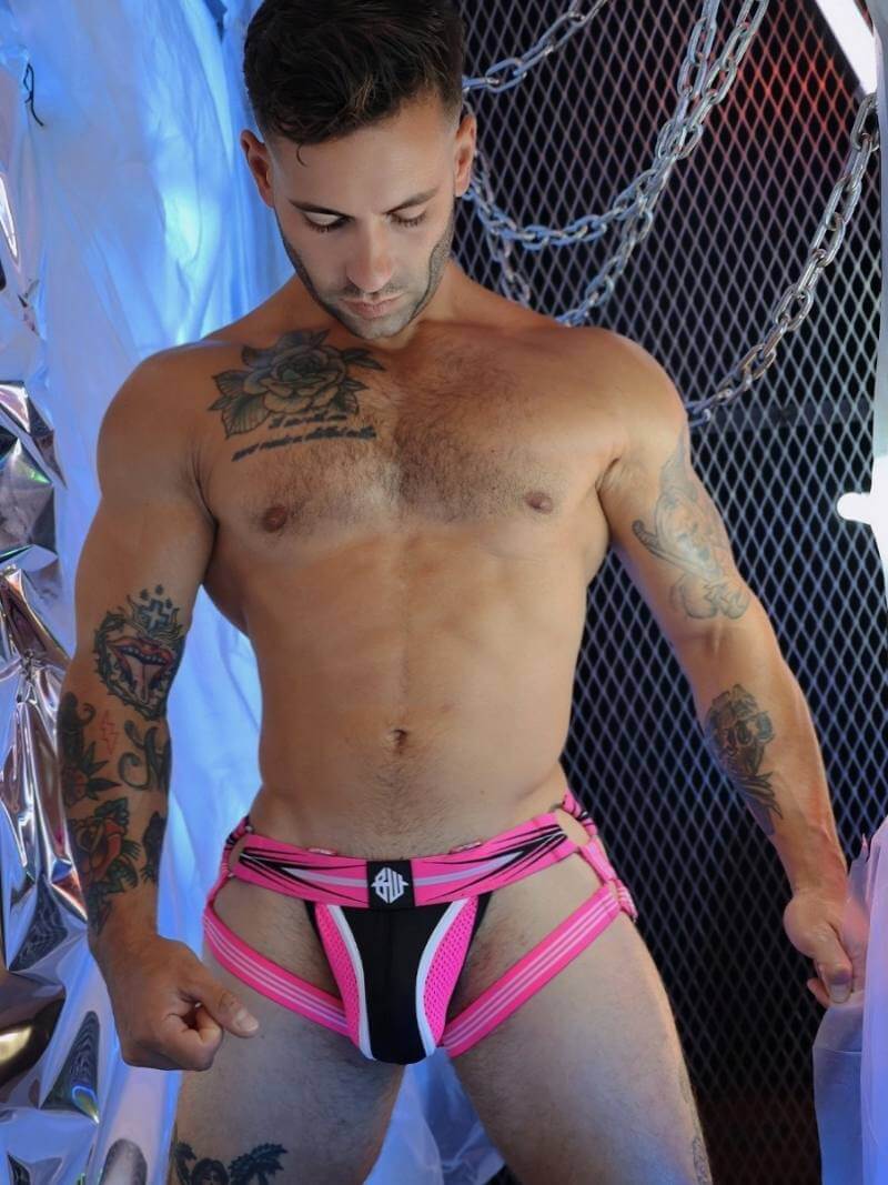 Man wearing a pink and black partywear jockstrap with garter leg straps
