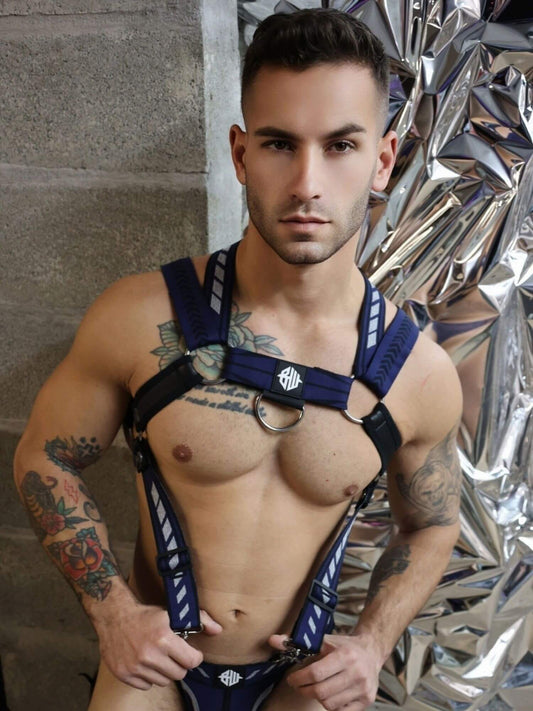 Man wearing a blue harness against a reflective surface