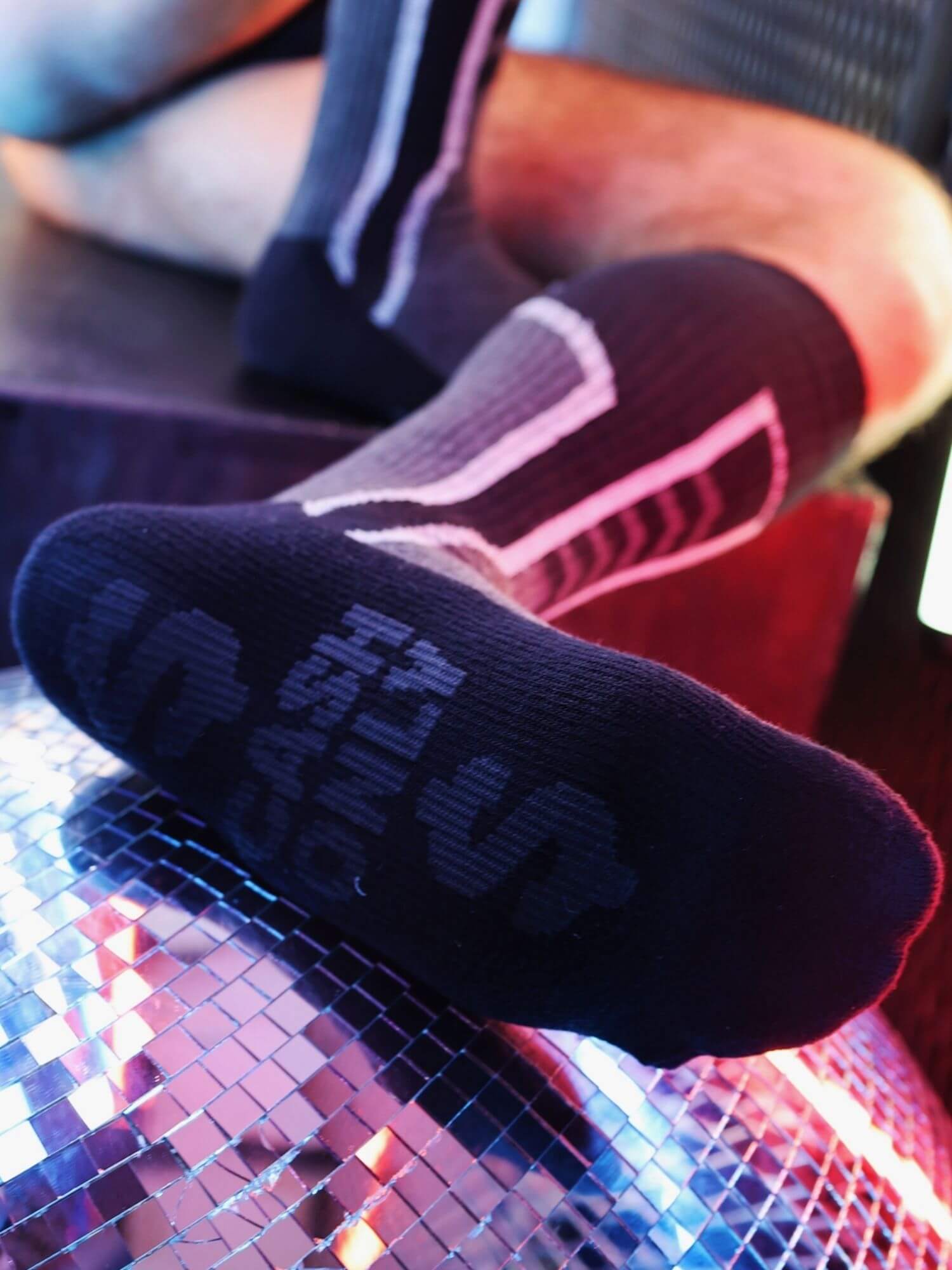 Black socks with navy text on a colorful surface