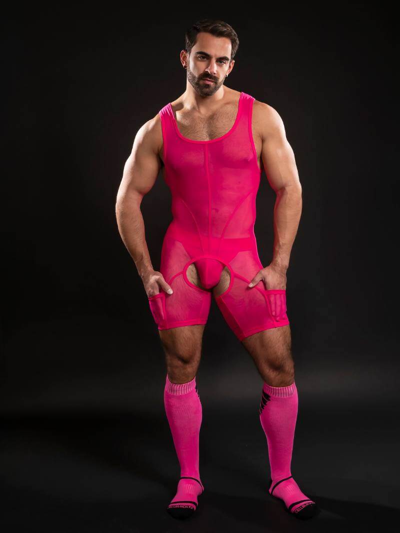 Man wearing a bright pink outfit on a black background