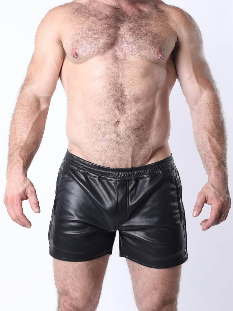 Man wearing black leather shorts on a white background