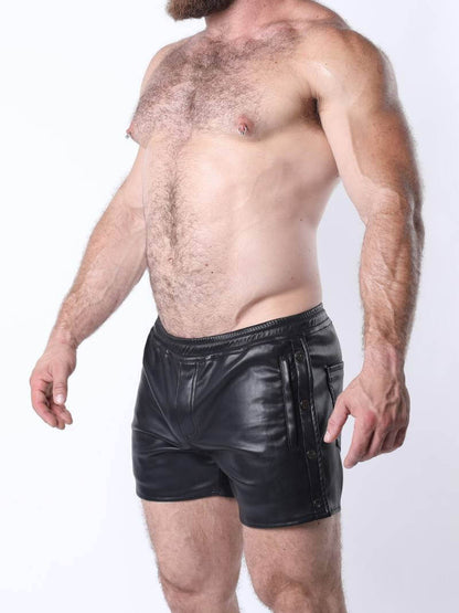 Man wearing black leather shorts on a white background
