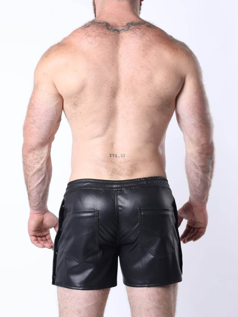 Man wearing black leather shorts on a white background