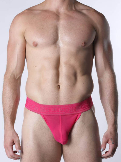 Man wearing a bright pink men's underwear on a white background