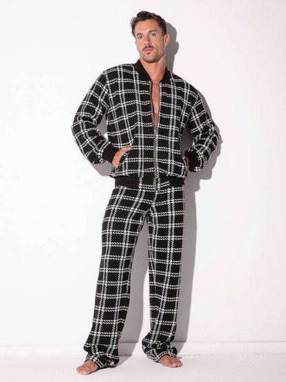 Man wearing a black and white checkered pajama set on a white background