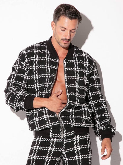 Man wearing a black and white checkered jacket and pants on a white background