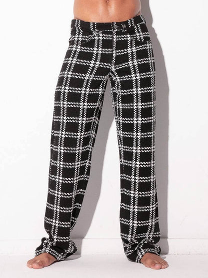 Black and white plaid pajama pants worn by a person on a white background