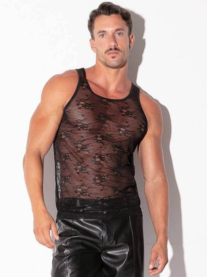 Man wearing a black lace tank top and shiny black pants against a white background