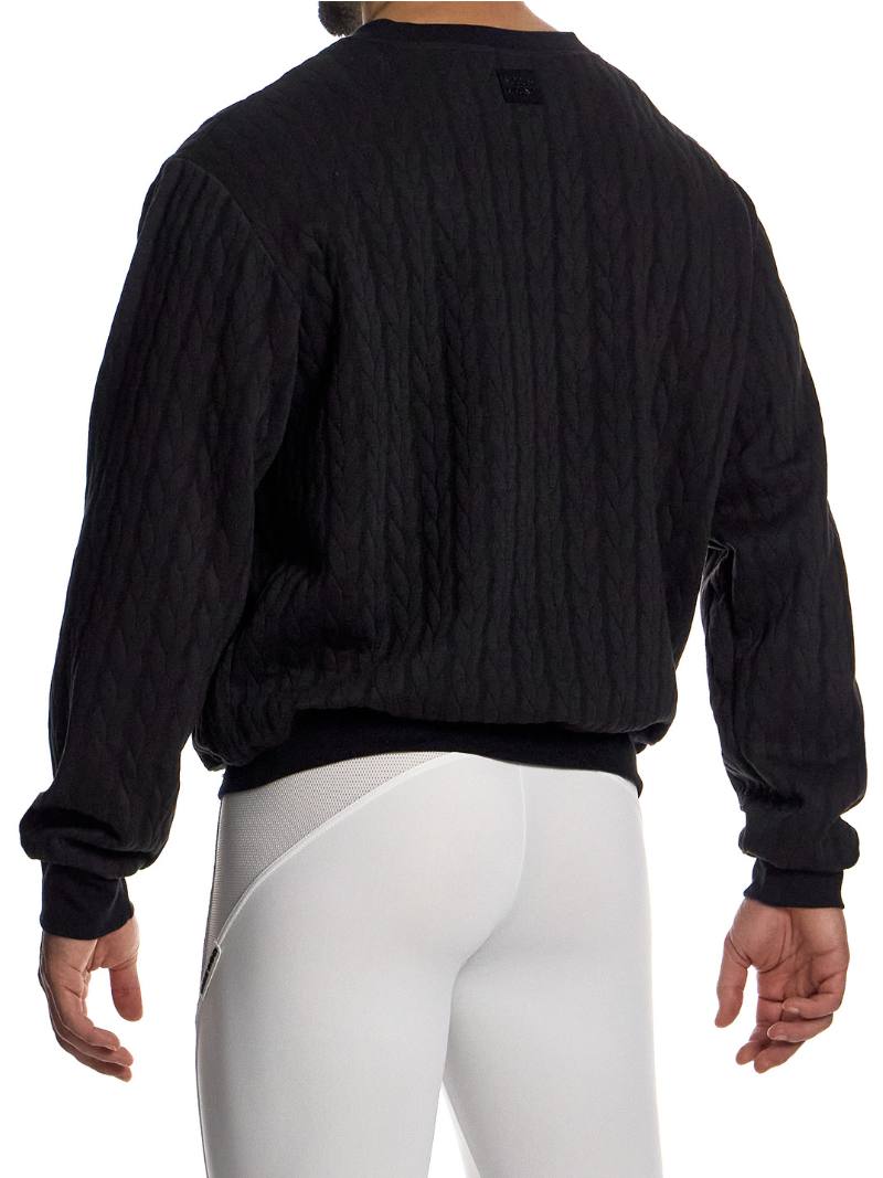 Person wearing a black equestrian jacket and white pants on a white background