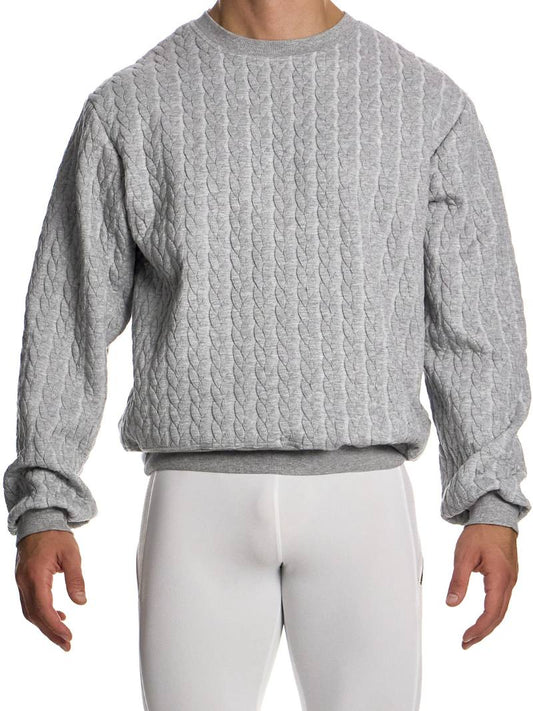 Person wearing a textured gray sweater and white pants on a white background