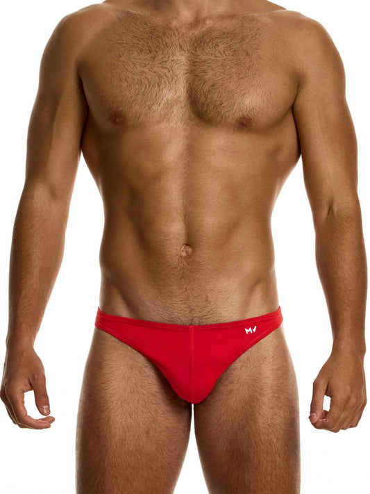Man wearing a red low cut brief on a white background