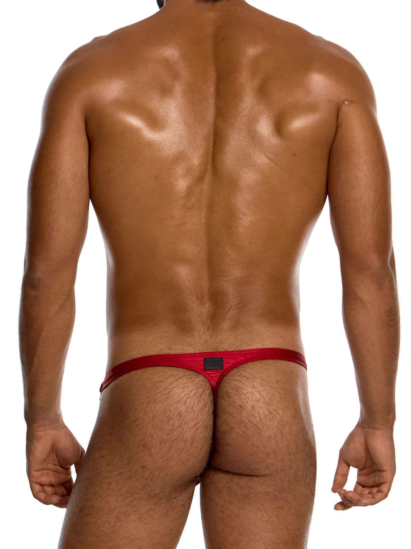 Man wearing a red swimming thong on a white background