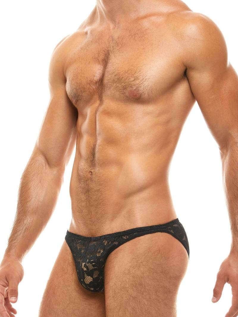 Man wearing a black lace thong against a white background