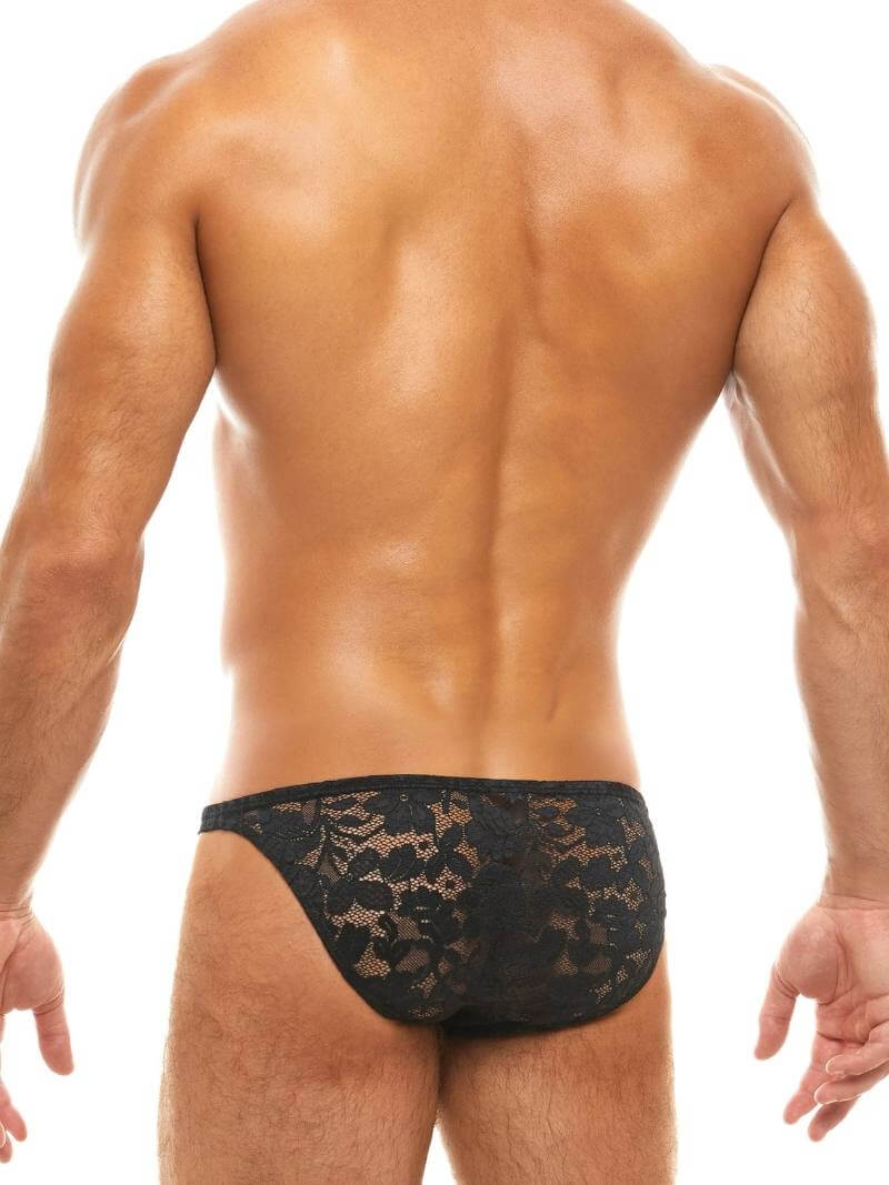 Man wearing black lace underwear on a white background