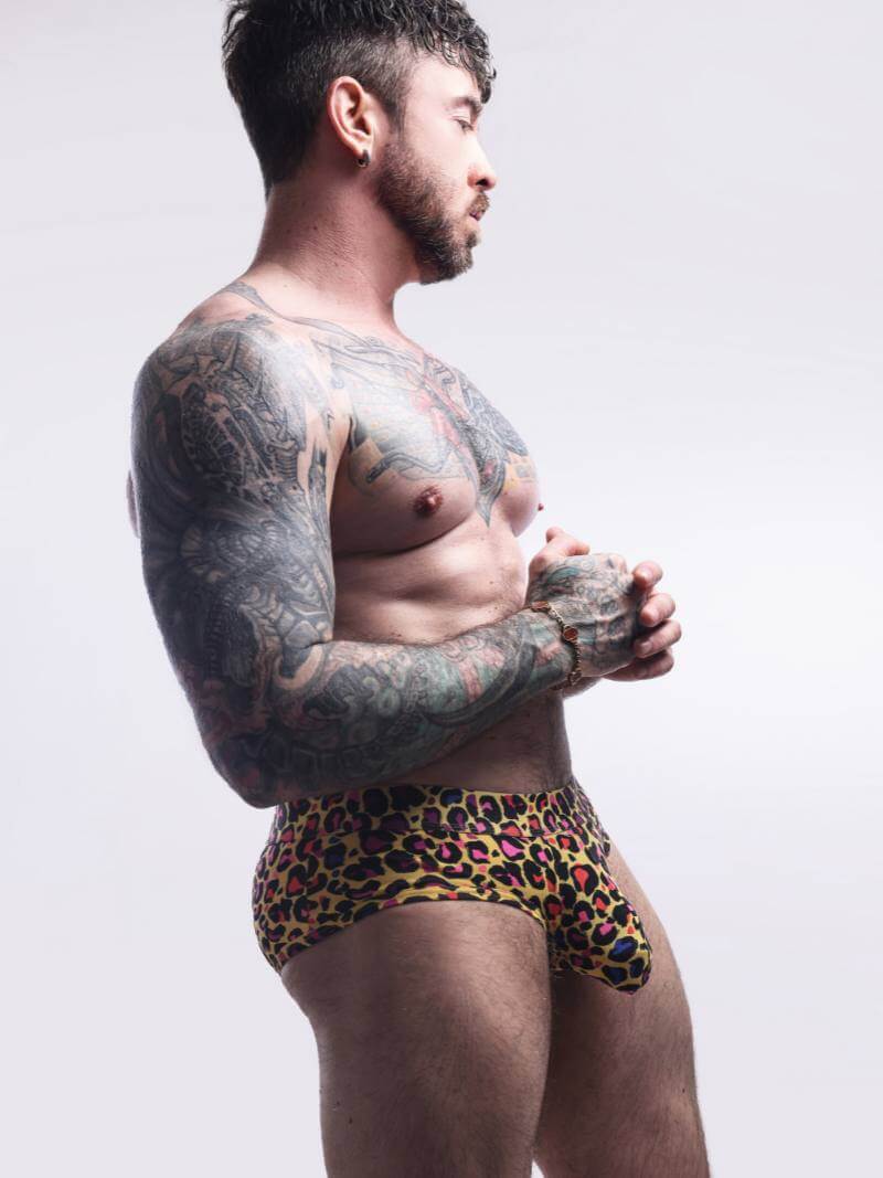 Man wearing a leopard print swimsuit against a plain background