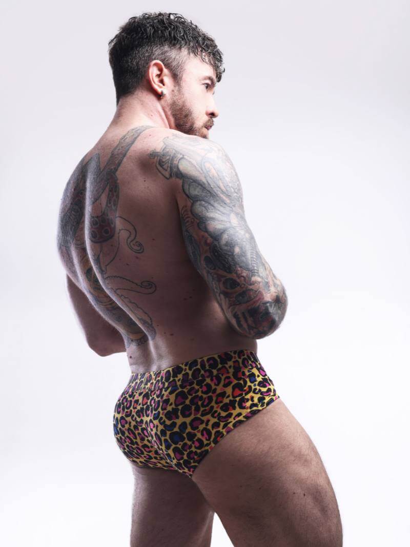 Man wearing a leopard print swimsuit against a white background