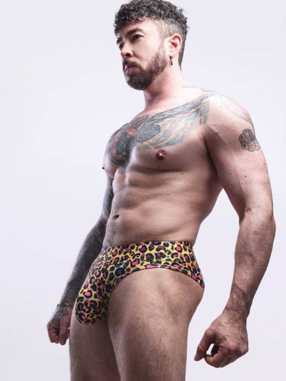 Man wearing colorful leopard print underwear against a white background
