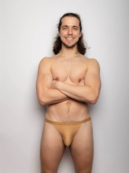 Man wearing beige gay SUKREW underwear thong against a plain background