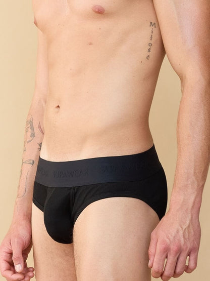 Man wearing black underwear with brand logo on a beige background