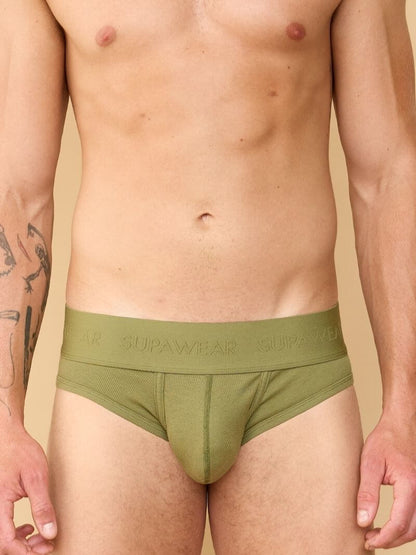 Man wearing green underwear with 'Supreem' branding on a beige background