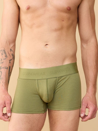 Person wearing green boxer briefs with 'Supawear' branding on a beige background